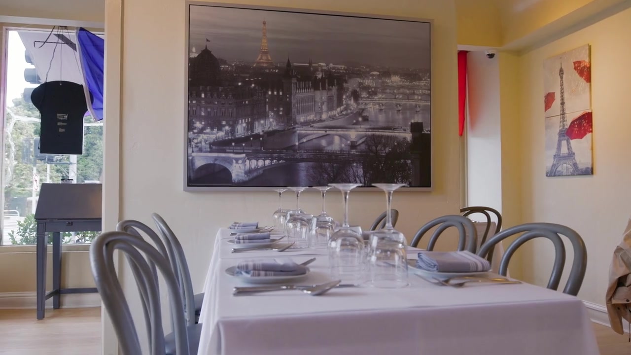 Chouchou San Francisco dining room with white tablecloths and Paris artwork.